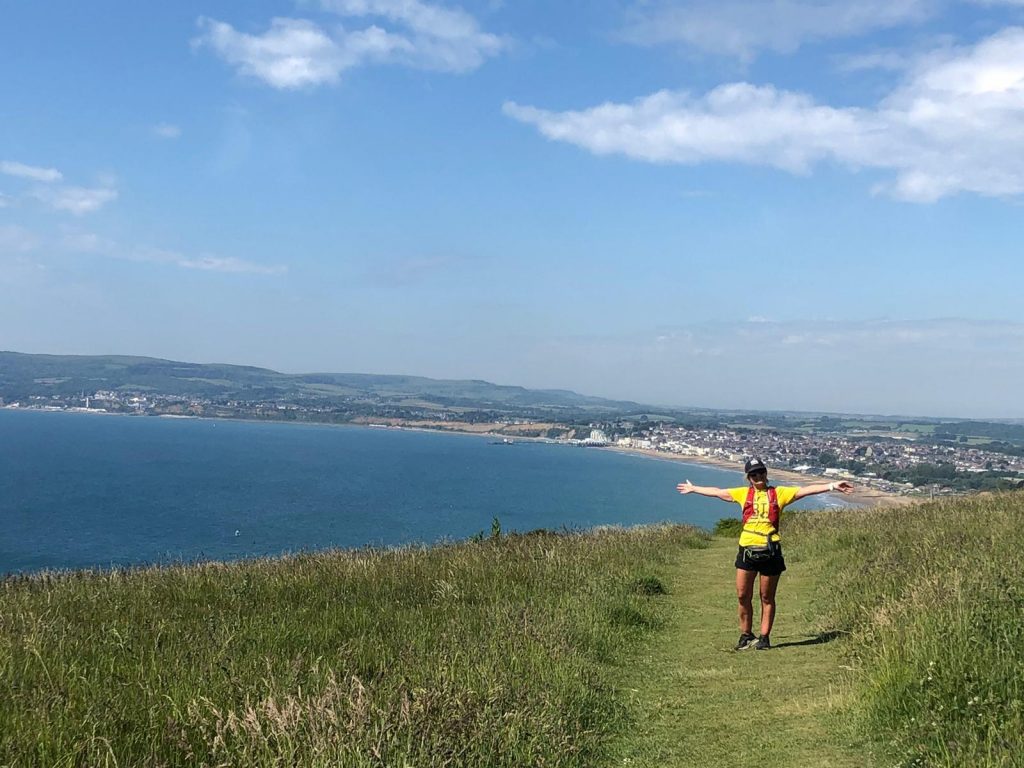 Alice Lane on her Isle of Wight adventure  standing on the coast with a view of the sea