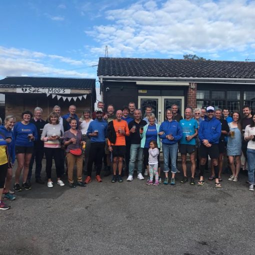 A large group of runners stood outside a pub