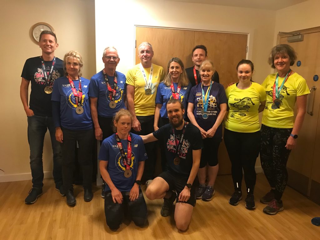 11 runners in finishers t-shirts and medals