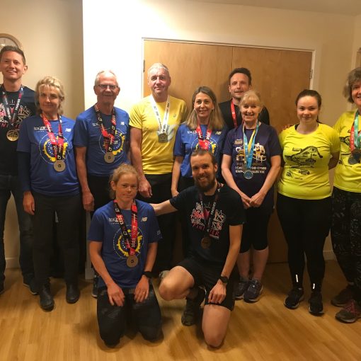 11 runners in finishers t-shirts and medals