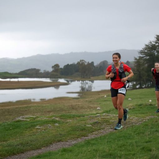 A woman running next to a lake